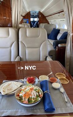 an airplane meal is on the table in the middle of the aisle with two seats behind it