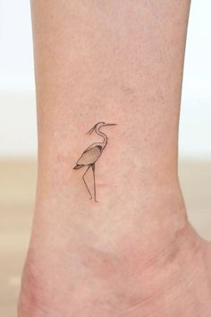 a small bird tattoo on the ankle