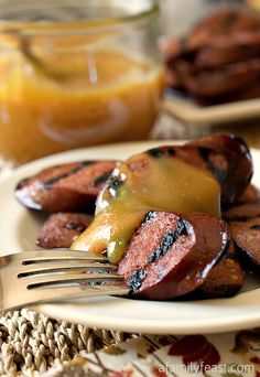 grilled sausages with orange sauce on a white plate