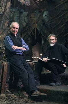 two men sitting on steps in front of a tree