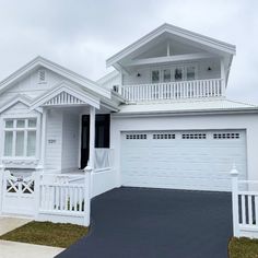 a white house with an attached porch and two car garages