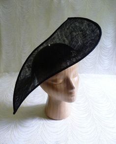 "One large sinamay straw hat base in black in an oblong shape that measures approximately 13\" (33.00 cm) at its widest point and approximately 17\" (43.18 cm) at its longest point. Deep curvature to fit against your head. The stiffened sinamay straw is feather light but has a great sturdy weave that provides excellent support for your millinery creations. Edge finished with sinamay. Shipped in an oversized box, hence the higher than normal postage charge. May have to ship separately for some in Black Adjustable Boater Hat For Formal Occasions, Black Short Brim Boater Hat For Church, Formal Black Boater Hat With Curved Brim, Classic Black Wedding Hat, Classic Fitted Black Mini Hat, Fitted Sinamay Fascinator For Summer, Summer Sinamay Fascinator, Fitted, Summer Fitted Sinamay Fascinator, Black Mini Hats For Summer Church Events