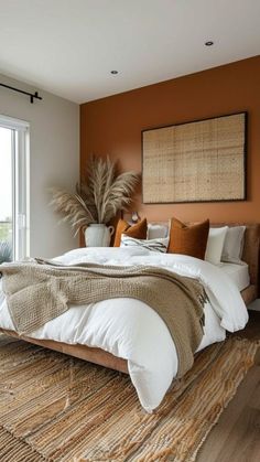 a large bed sitting on top of a wooden floor next to a tall glass window