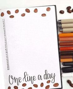 an open notebook with coffee beans and crayons next to it that says, one line a day