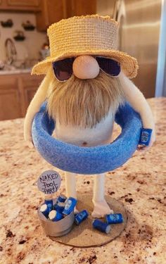 a close up of a figurine on a counter top with sunglasses and a hat