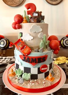 a birthday cake with cars and trucks on the top is made to look like it's going to be a race