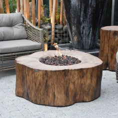 a fire pit sitting on top of a wooden table next to a couch and chair