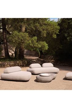 an outdoor seating area in the middle of a park with trees and bushes behind it