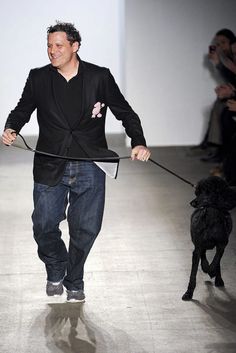 a man is walking with a dog on a leash in the middle of a runway