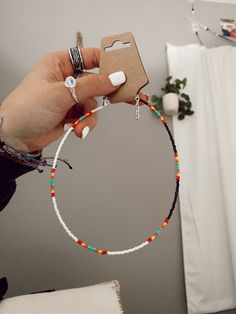 a person holding up a bracelet with beads