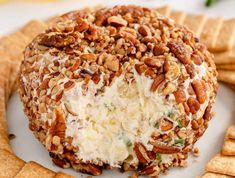 a cheese ball covered in nuts on top of crackers