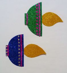 two pieces of glittered paper with different shapes and colors are shown on a white surface