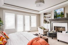 a bedroom with a fireplace and white furniture