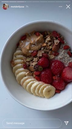 a bowl filled with oatmeal and fruit on top of a white table