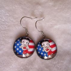 pretty pair of betty boop earrings on an American flag background, dimension of the cabochon 2cm or 1.8cm, total height of the loop: 4.2cm made by me from the printing of the image to the assembly of the different elements, it is important to me to create beautiful, unique and quality jewelry stainless steel support, quality product, eliminates the risk of allergies American Flag Background, Flag Background, The Loop, Betty Boop, Quality Jewelry, Assemblage, Allergies, Favorite Jewelry, American Flag