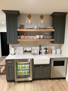 a kitchen with gray cabinets and white counter tops, stainless steel appliances and open shelving