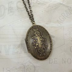 "A lovely oval shaped locket with a raised floral and leafy vine design is featured in this beautiful pendant. The locket is solid brass of exceptional quality made in the US from a family owned business using vintage tooling. It has a gorgeous rich antiqued finish giving it a wonderful vintage vibe. Locket measures 1 5/8\" high by 1 1/8\" across. The chain is a solid brass cable chain of very high quality. It is made and plated in the US from a family owned business. Matching lobster clasp is a Annie Props, Victorian Gothic Jewelry, Locket Jewelry, Victorian Locket, Fire Opals Jewelry, Blue Opal Necklace, Edgy Jewelry, Antique Locket, Whimsical Jewelry