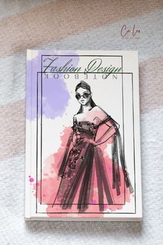 the fashion design book is laying on top of a white surface with pink and purple watercolor