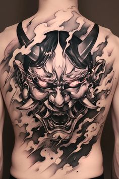 the back of a man's body with tattoos on his chest and an image of a demon