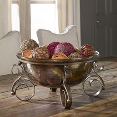 a metal bowl filled with lots of different types of food on top of a wooden table