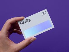 a person holding up a business card with the word really on it in front of a purple background