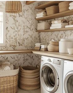 a washer and dryer in a laundry room with wall paper on the walls