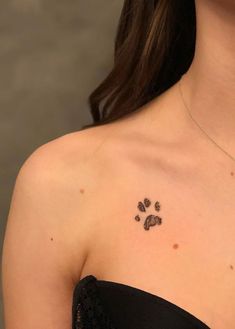 a woman wearing a black strapless dress has a paw print on her chest