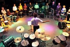 a man standing in front of a group of drummers