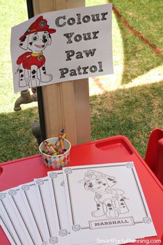 a sign that says, color your paw patrol on it next to some markers and pencils