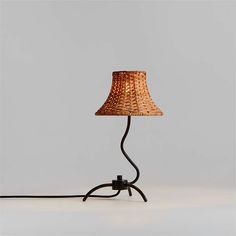 a lamp that is sitting on top of a table next to a light bulb with a cord