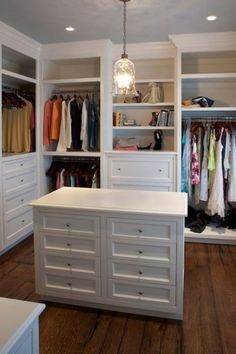 a walk in closet with white cabinets and drawers