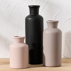 three vases sitting on top of a wooden table