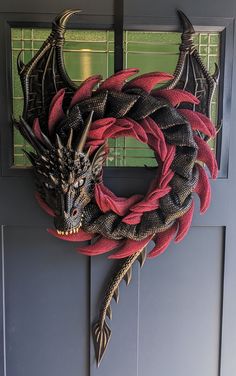 a red and black dragon wreath hanging on a door