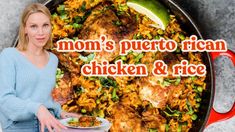 a woman standing in front of a pan filled with chicken and rice