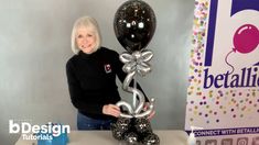 a woman standing next to a table with balloons