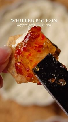 a piece of food that is being held in someone's hand with a knife