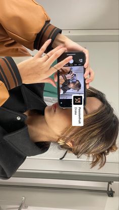 a woman is taking a selfie with her cell phone in front of her face