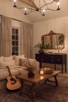 a living room filled with furniture and a guitar sitting on top of a coffee table