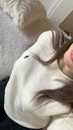 a woman with long brown hair laying on the floor next to a white teddy bear