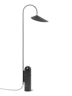 a black lamp with a white background and an object on the floor next to it