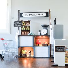 an open refrigerator sitting on top of a wooden floor next to a sign that says local fresh