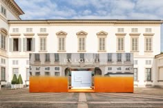 an open door in front of a large white building