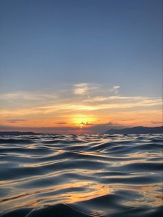 the sun is setting over the ocean as it reflects in the water's surface