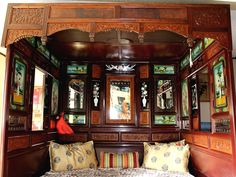 a bed in a room with wooden paneling and mirrors on the wall above it