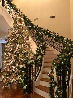 a staircase decorated for christmas with garland and lights on the bannister railings