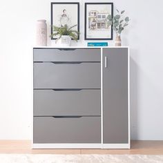 a gray and white dresser with pictures on the wall next to it's drawers