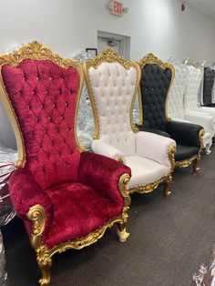 three chairs with gold trim and red velvet upholstered on the back are in a store