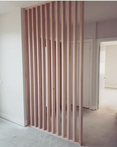 an empty room with wooden slats on the wall