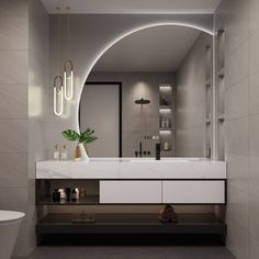 a modern bathroom with an oval mirror above the sink and vanity area, along with a toilet