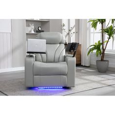 a white recliner chair with a laptop on it's back and blue light underneath